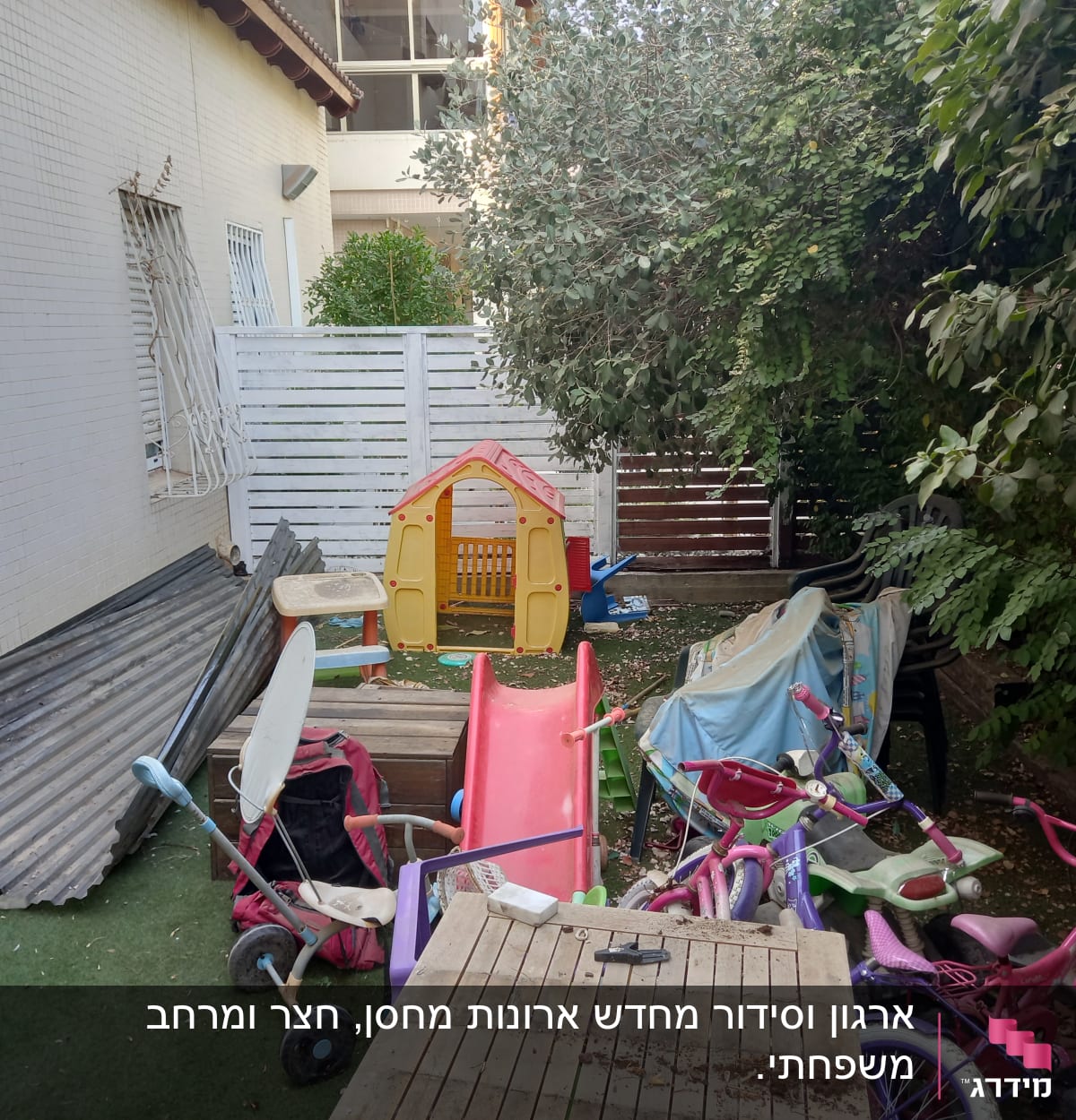 חצר עם צעצועים, אופניים, מגלשה ובית משחקים לילדים